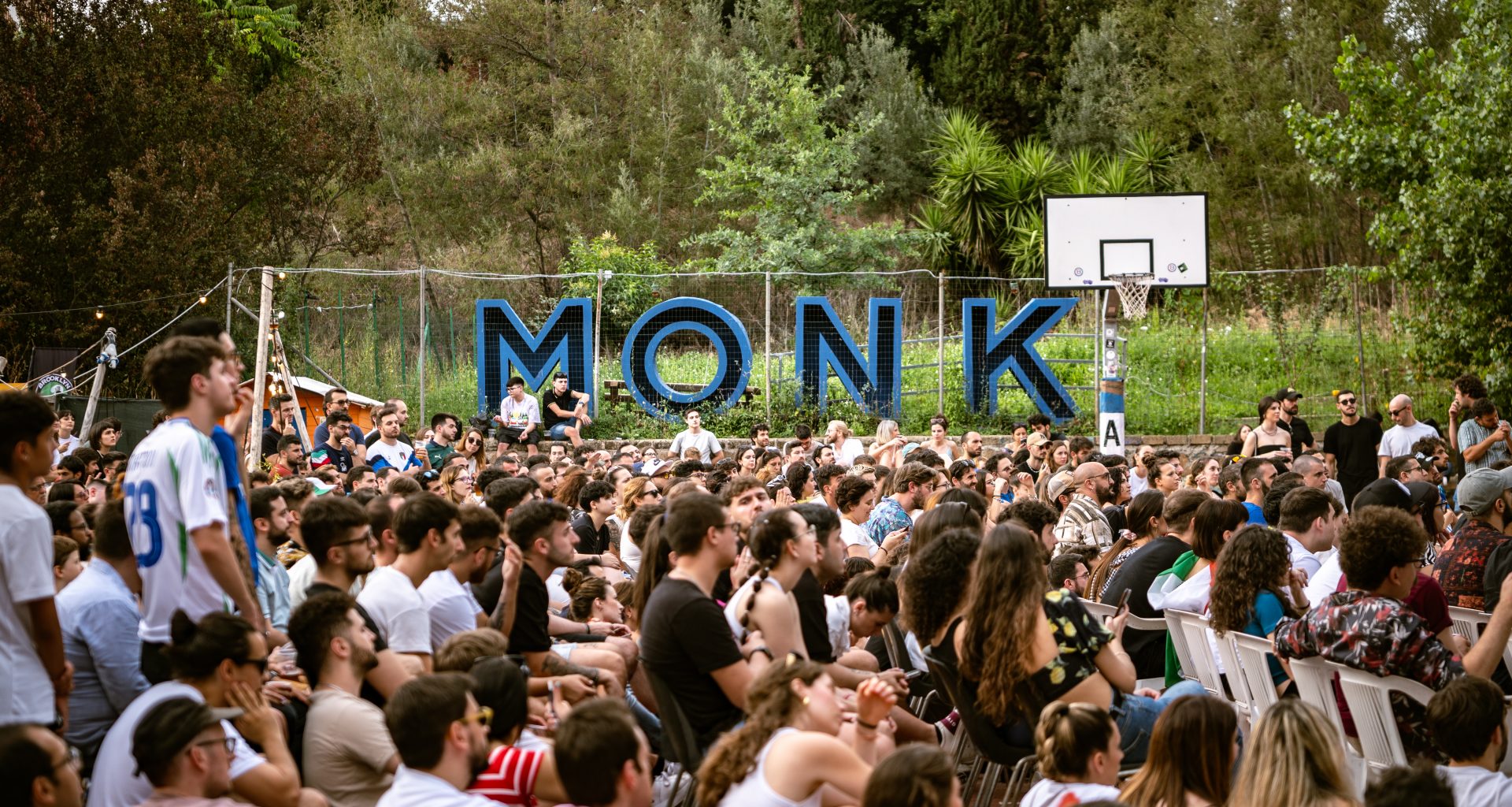 people sitting in basketball field with countryside in the background at monk roma xceed