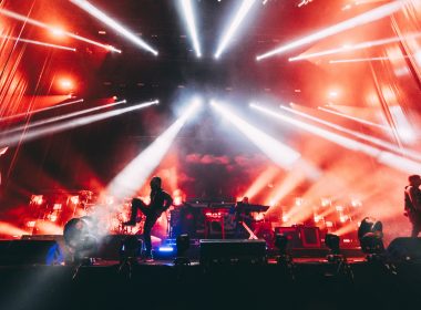 The Prodigy performing at Kalorama Madrid with intense red and white lighting effects, as the band members are silhouetted against a backdrop of smoke and lasers