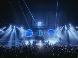 Atmospheric shot of the Sound Waves Winter Edition stage at Carlos Lopes Pavilion, featuring stunning laser visuals and a packed crowd under dynamic lighting.